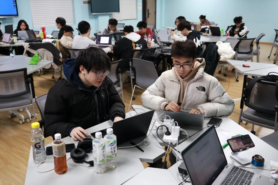 第二届 UP 训练营同学在教室中分组使用电脑推进项目